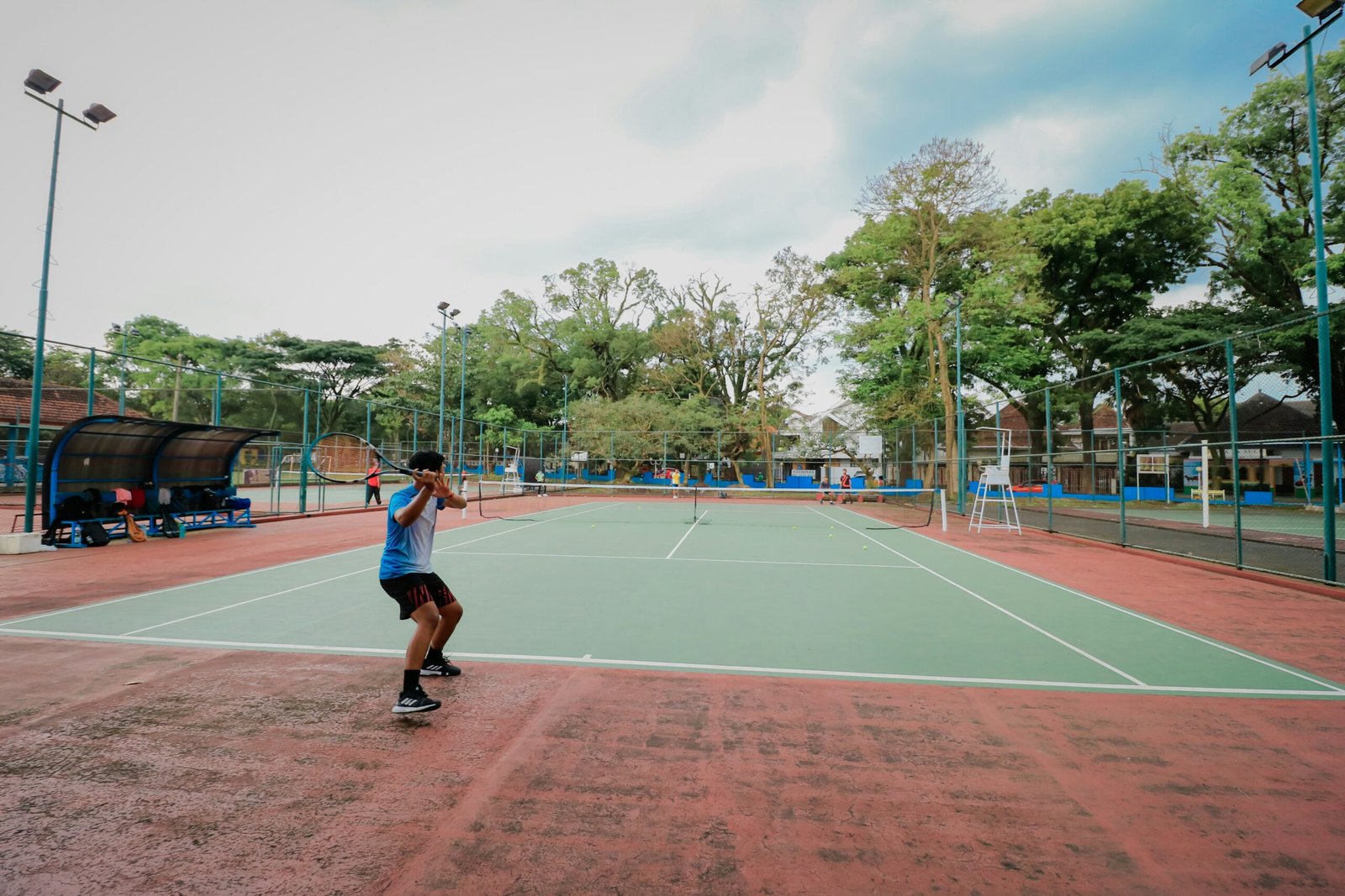 a man standing on a tennis court holding a racquet